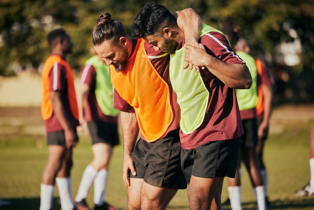 Injured sports player carried by a teammate